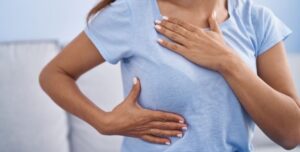 mujer sujetándose el pecho con camiseta
