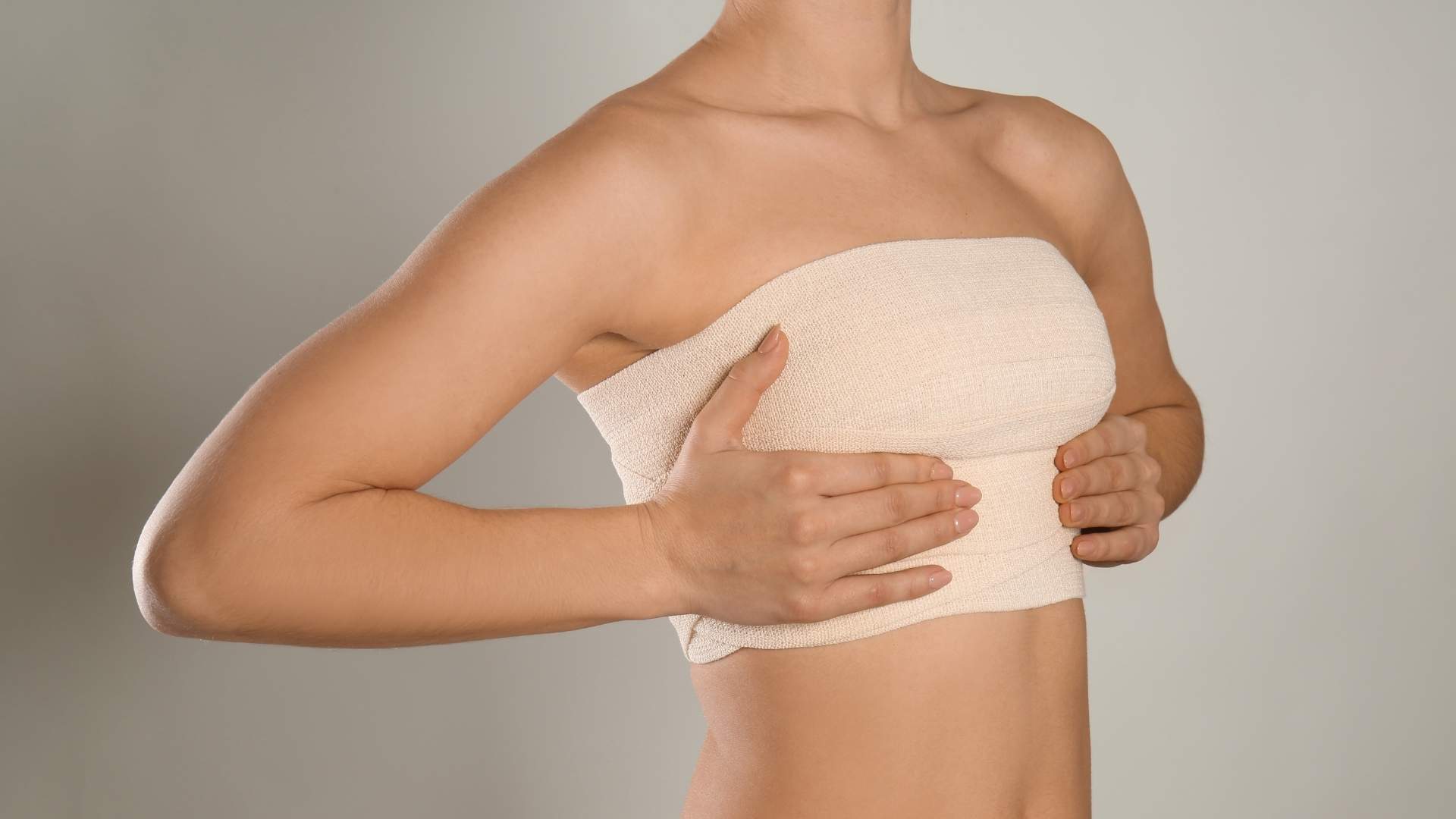 Mujer palpándose los pechos tras operación de mastopexia