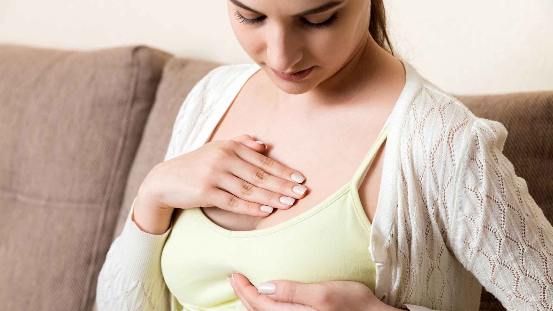 Mujer comprobando sus pechos tras operación de aumento de pecho